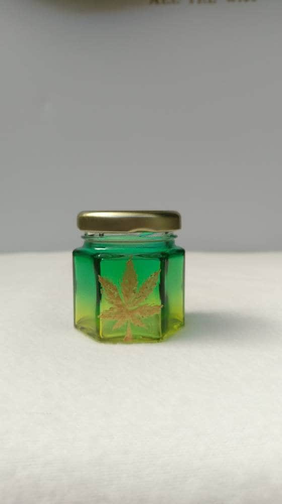Hand Stained-Painted glass nug jar- yellow fading to green( ombre) with a pot leaf painted on top in gold paint.