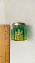 Load image into Gallery viewer, Hand Stained-Painted glass nug jar- yellow fading to green( ombre) with a pot leaf painted on top in gold paint.
