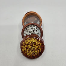Load image into Gallery viewer, Small 4 part Herb Grinder with Kief catcher. Hand painted gold mandala on imitation wood. Sharp teeth, magnetic closure with smooth grinding

