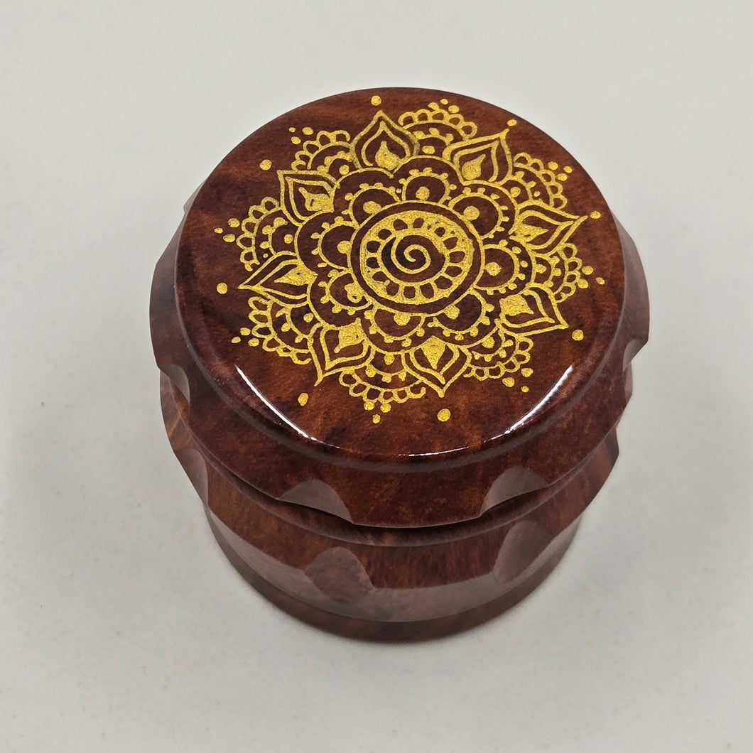 Small 4 part Herb Grinder with Kief catcher. Hand painted gold mandala on imitation wood. Sharp teeth, magnetic closure with smooth grinding